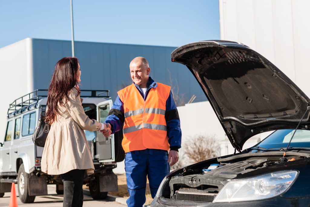 Woman shaking hands with mechanic car breakdown Woman shaking hands with mechanic car breakdown